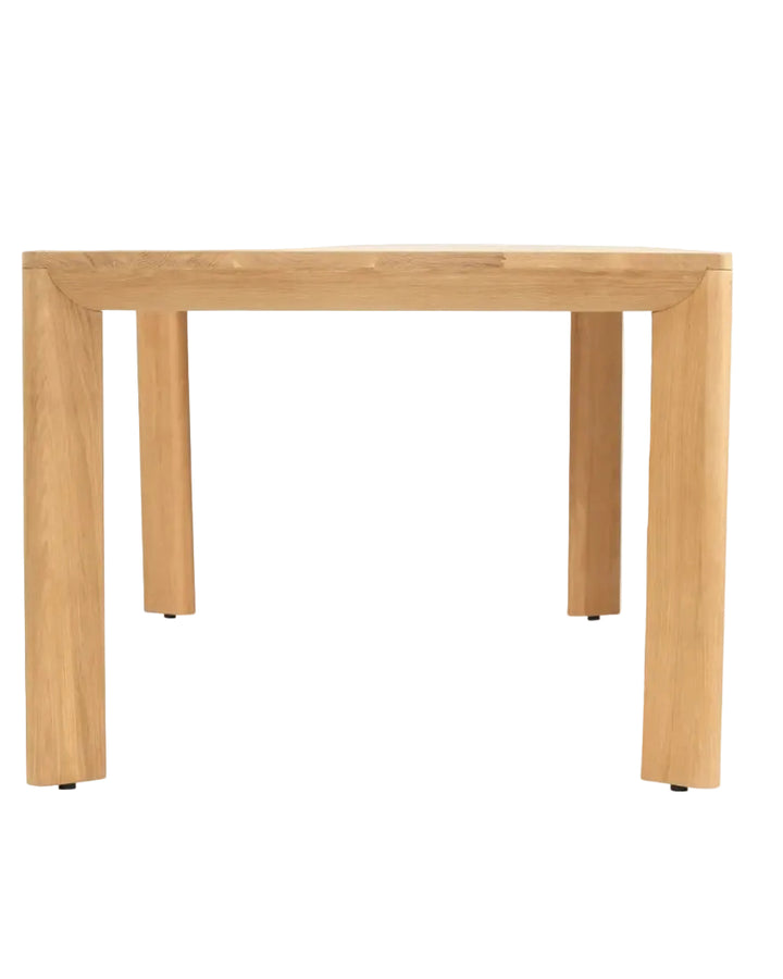A light natural oak dining table with a square top and four thick block legs, shown from a front-facing perspective on a white background.