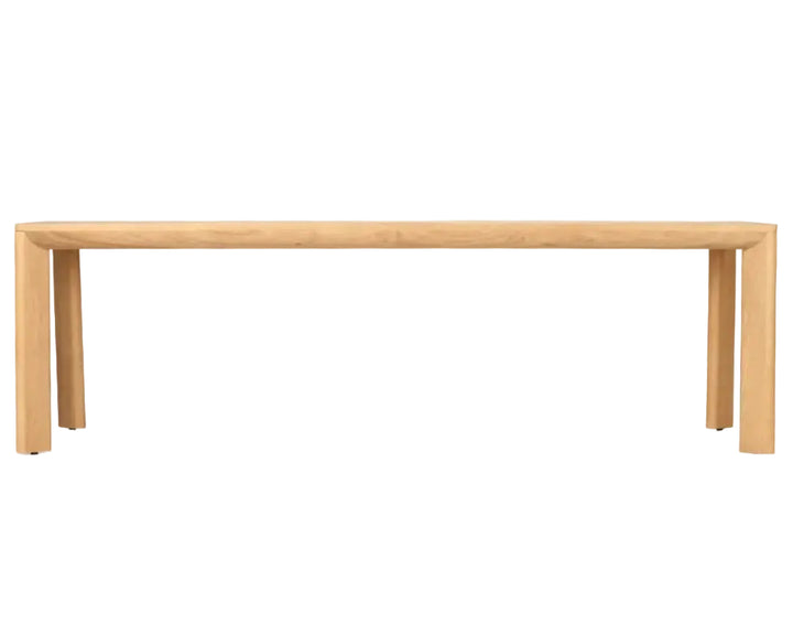 A minimalist light oak wood dining table with a thick rectangular top and blocky, tapered legs, shown against a solid white background.