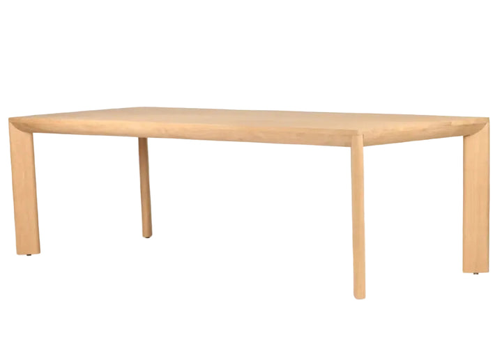 A minimalist rectangular wooden table with a light natural oak finish, featuring a thick top and tapered legs, shown on a solid white background.