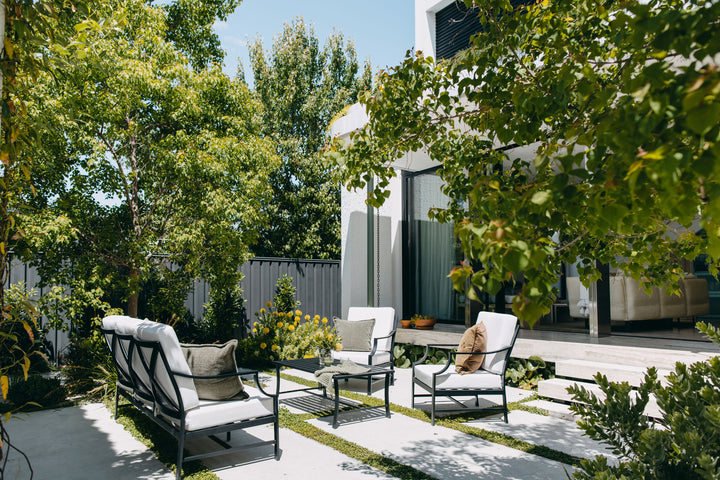 Portofino Outdoor Lounge Set in Black styled in an open-air courtyard with mature trees in the sunshine