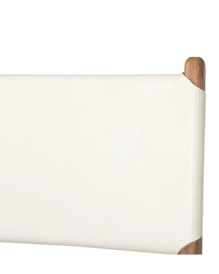 A modern Sutton Leather Dining Chair with a white cushion, teak wooden frame, and white leather upholstery, showing a close up of the back rest.