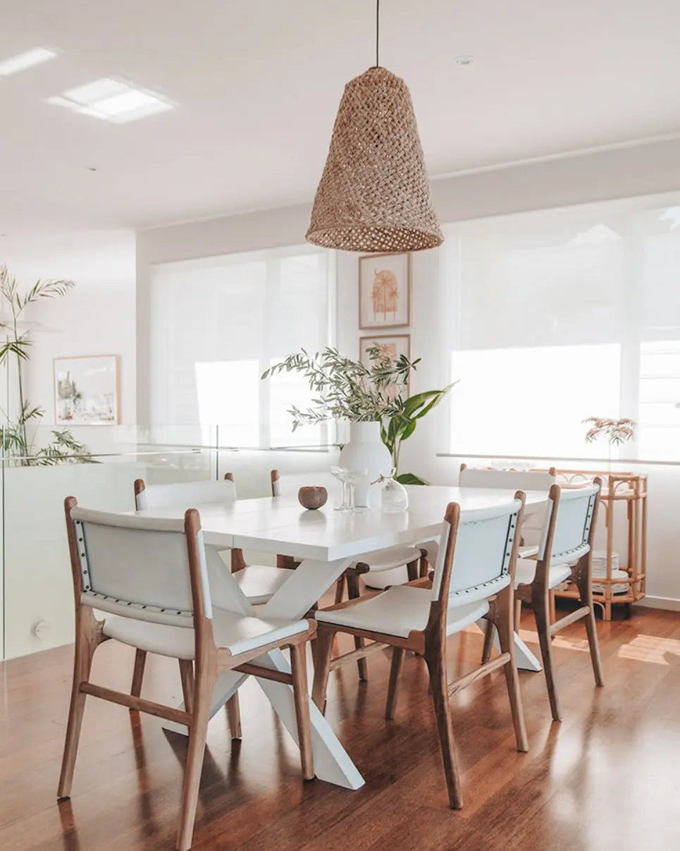 A modern dinging settin featuring the Sutton Leather Dining Chair with a teak wooden frame, and white leather upholstery.